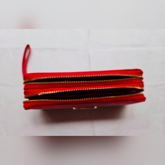Red wallet with 2 zipper compartments and a wrist handle. - Picture 10 of 12
